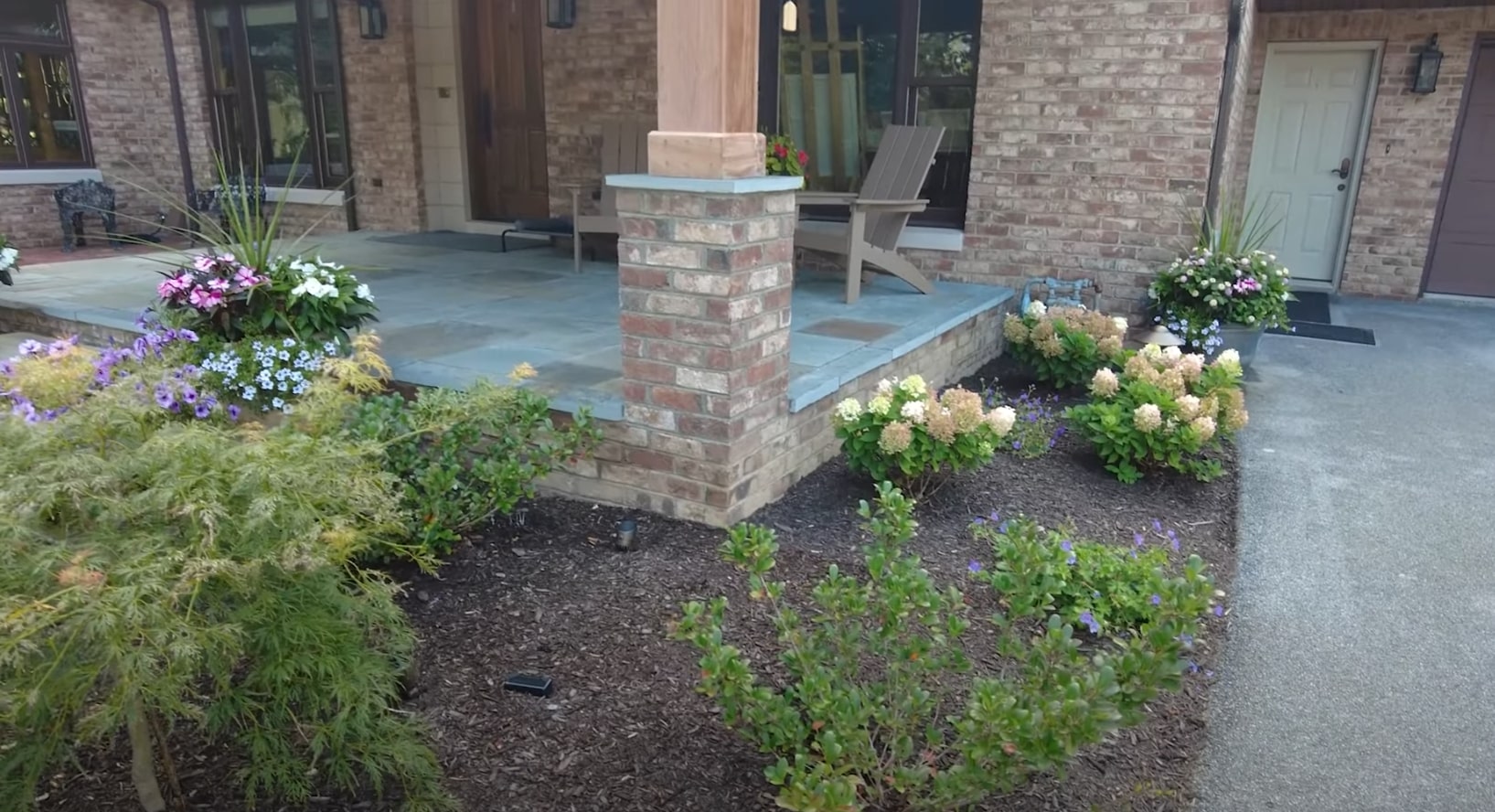 Foundation Landscaping and Hardscaping - Brookhaven Landscapers Professional hardscaping with brick columns, stone pathway, and foundation plantings around modern home