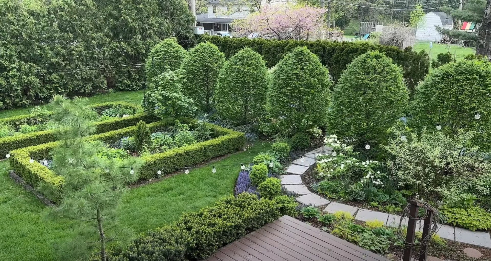 Multi-Level Garden with Integrated Lighting Multi-level garden design with curved pathways, integrated lighting, and diverse plant selections creating outdoor living spaces