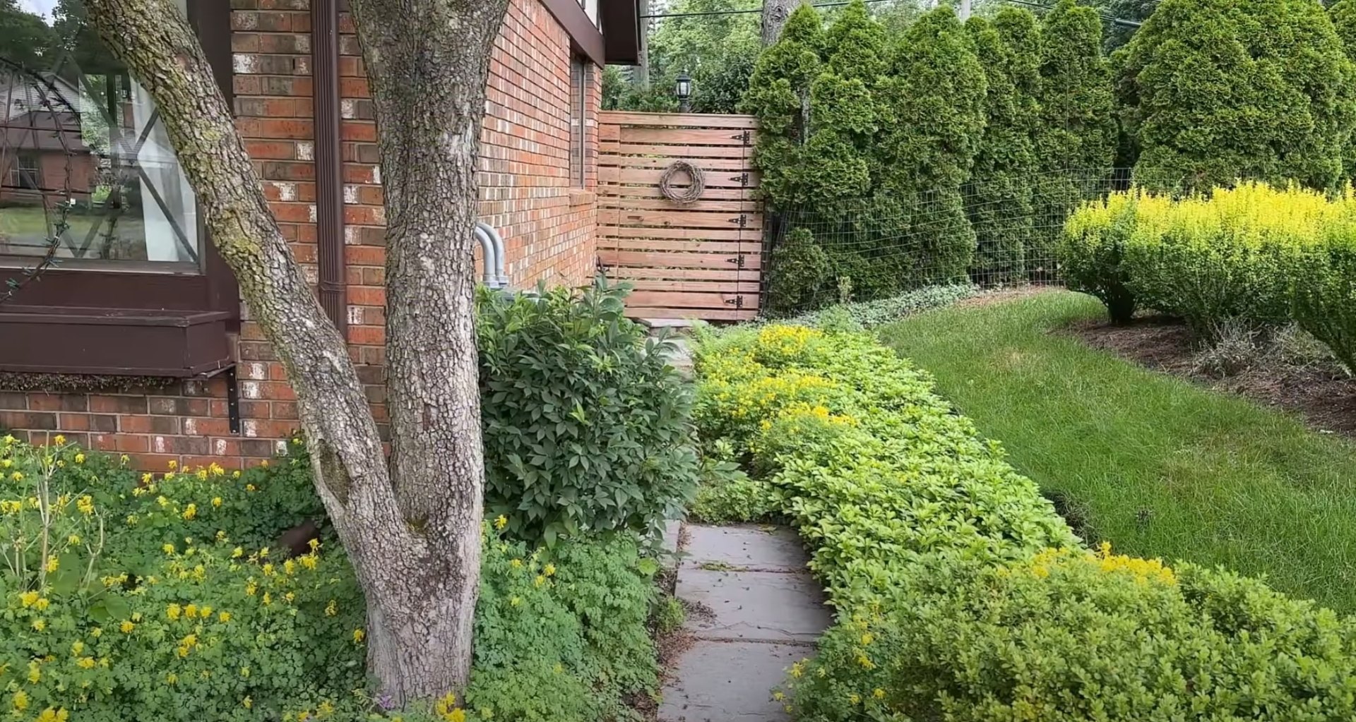 Professional landscape design featuring natural stone pathways and diverse plantings Beautiful residential landscape with curved pathway through lush garden beds and mature trees