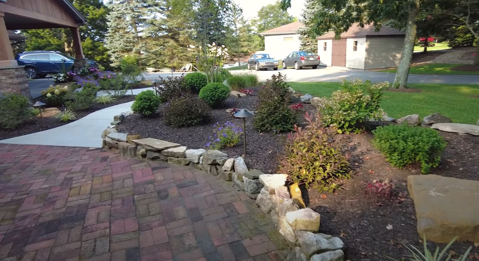 Natural Stone Water Feature Integration Natural stone water feature integrated into residential landscape with diverse plantings and professional mulching