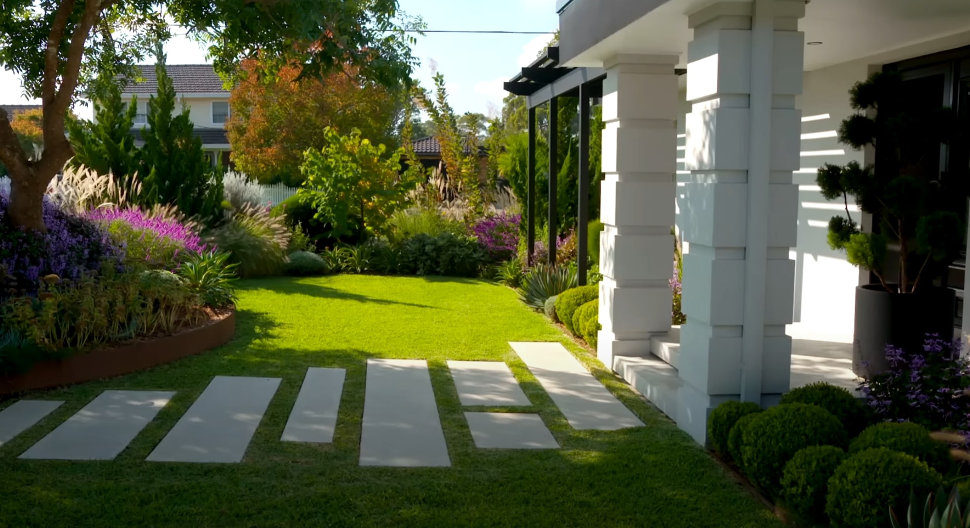 Modern Residential Landscape Design Modern residential landscape with geometric concrete pavers, vibrant flower borders, and architectural plant selections